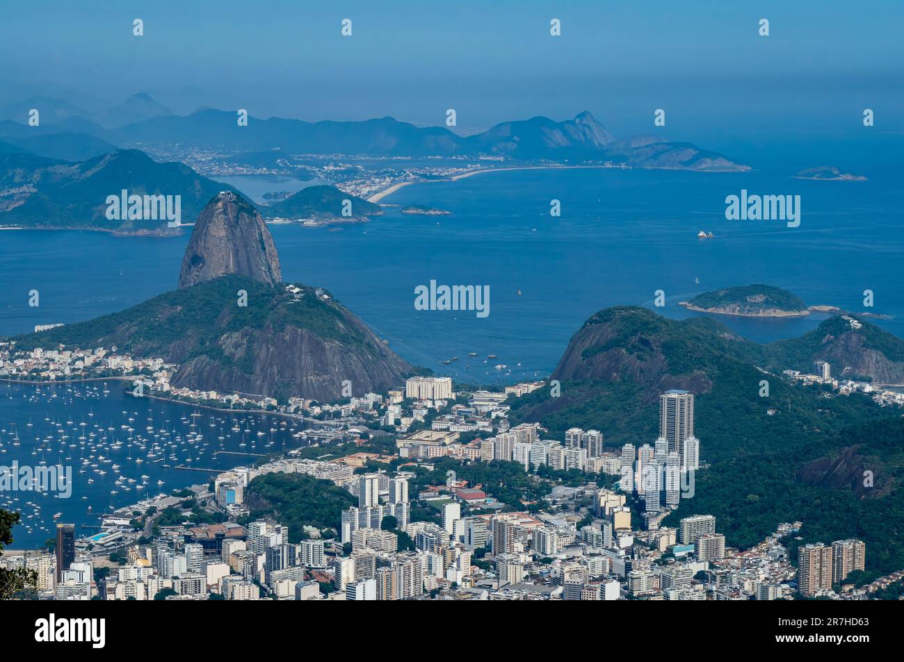 Vista in lontananza del Pan di zucchero, dei monumenti naturali della collina di Urca e del quartiere di Botafogo sottostante, come visto dalla cima del monte Corcovado durante la giornata estiva. Foto Stock