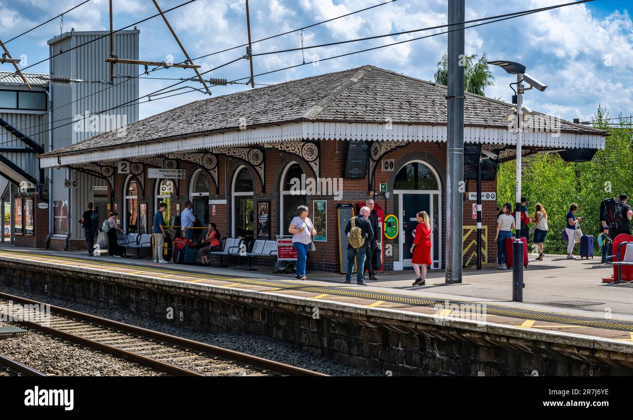 Stazione ferroviaria, Grantham, Lincolnshire, Regno Unito – passeggeri e persone che viaggiano in attesa di un treno alla stazione ferroviaria in un soleggiato pomeriggio estivo Foto Stock