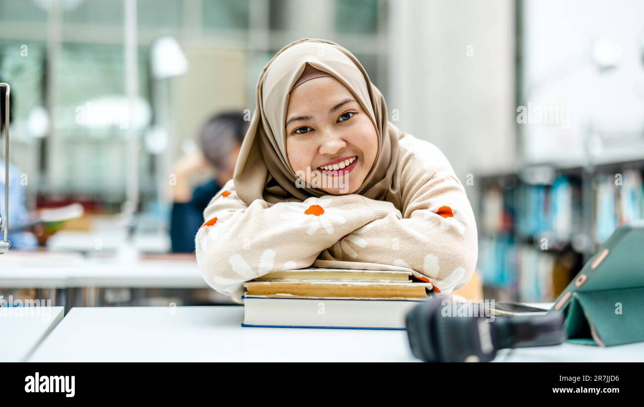 Ritratto di studentessa musulmana asiatica in biblioteca Foto Stock