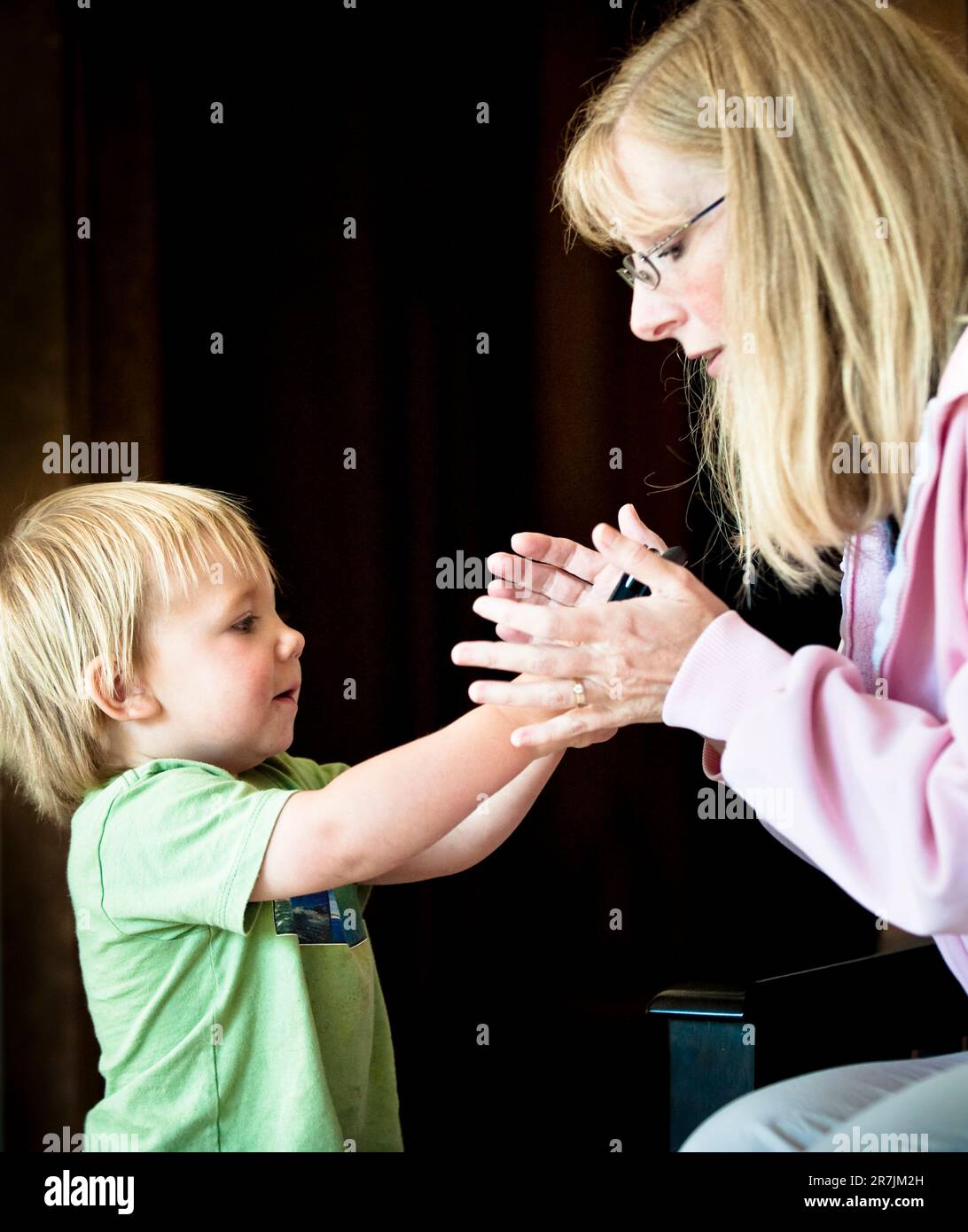 Una madre e un ragazzo stringono le mani insieme. Foto Stock