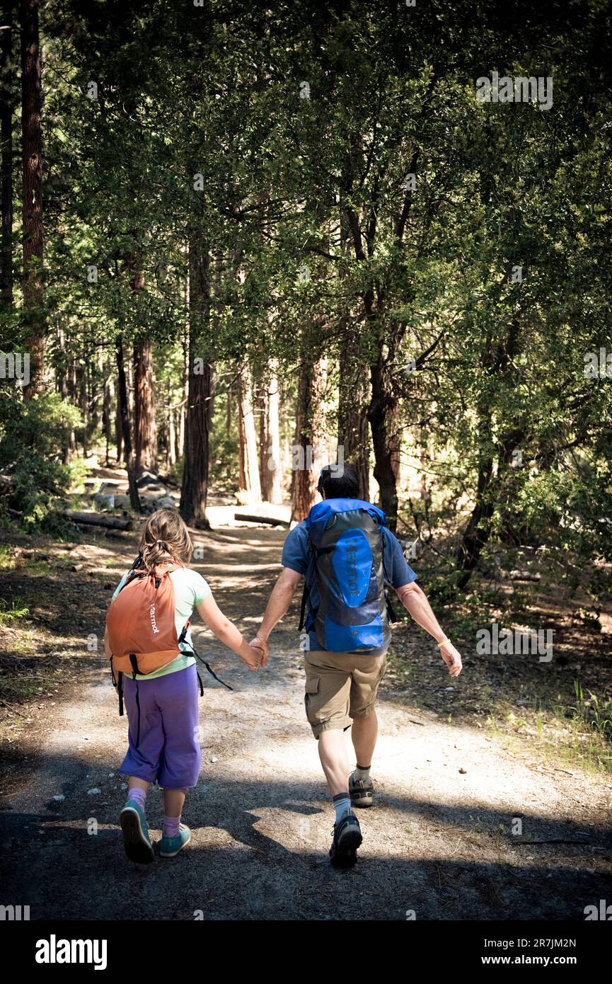 Un padre e una figlia hanno le mani che camminano a Yosemite Foto Stock
