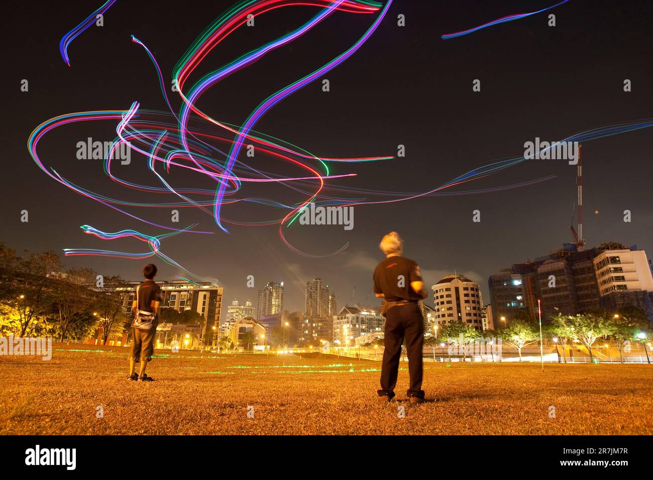 I membri del club Kite del Singapore Night Flyer illuminano il cielo serale con aquiloni telecomandati adornati da luci LED colorate. Foto Stock