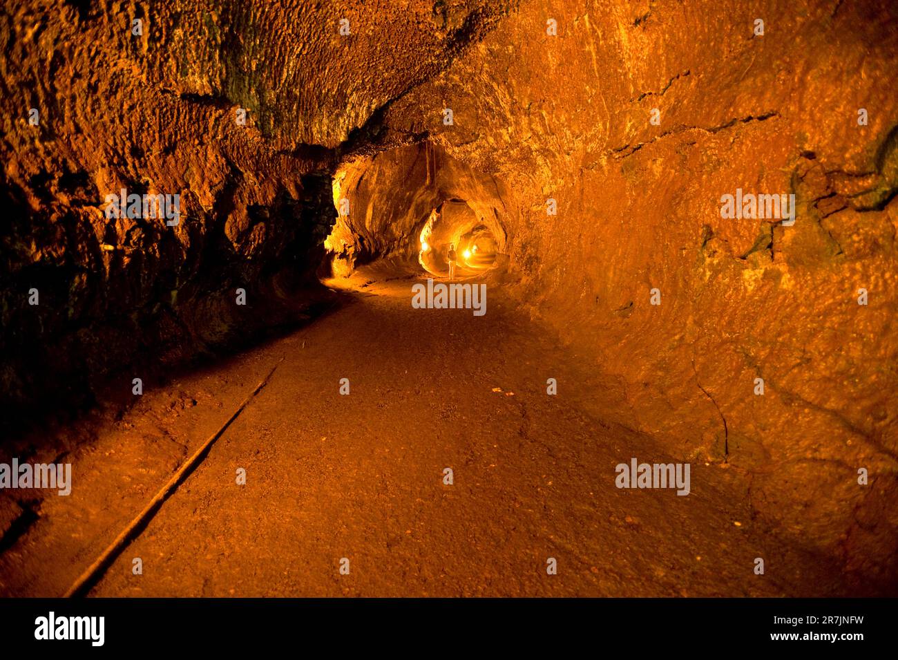 Una donna si trova molto in basso all'interno di un tubo di lava illuminato nel vulcano NP, ha, il 3/09/2010 Foto Stock