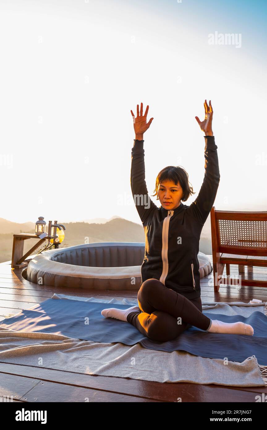 Donna che pratica yoga sul ponte di legno sopra Chiang Rai Foto Stock