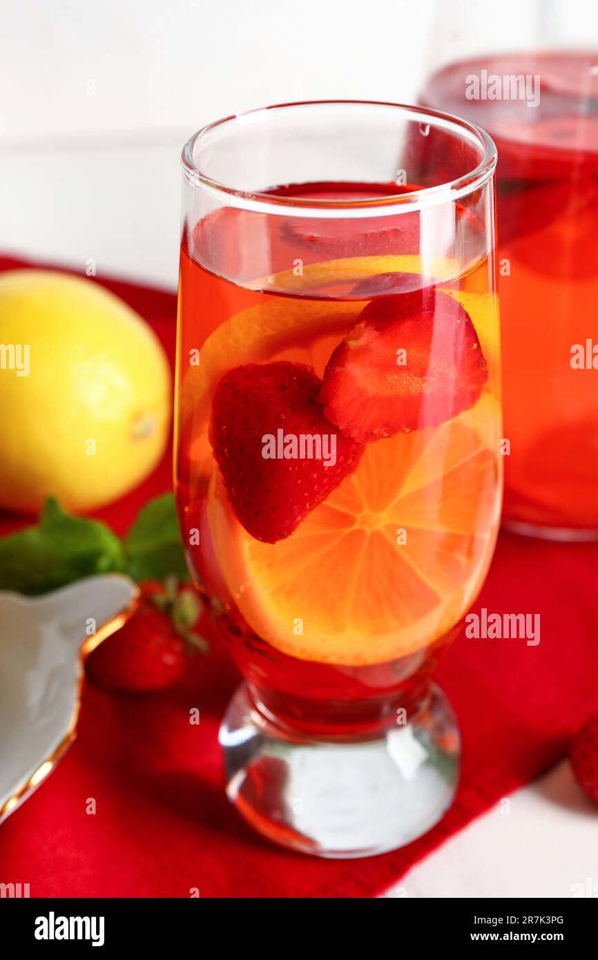 Bicchiere e caraffa di acqua infusa con fragola e limone, primo piano Foto Stock