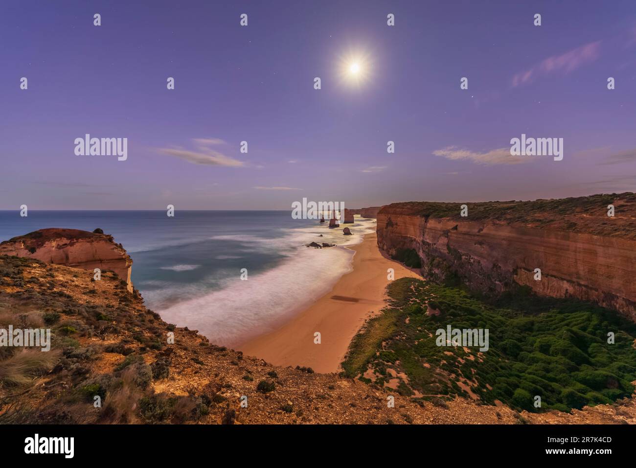 Australia, Victoria, lunga esposizione di luna che risplana sulla spiaggia sabbiosa nel Parco Nazionale di Port Campbell di notte Foto Stock