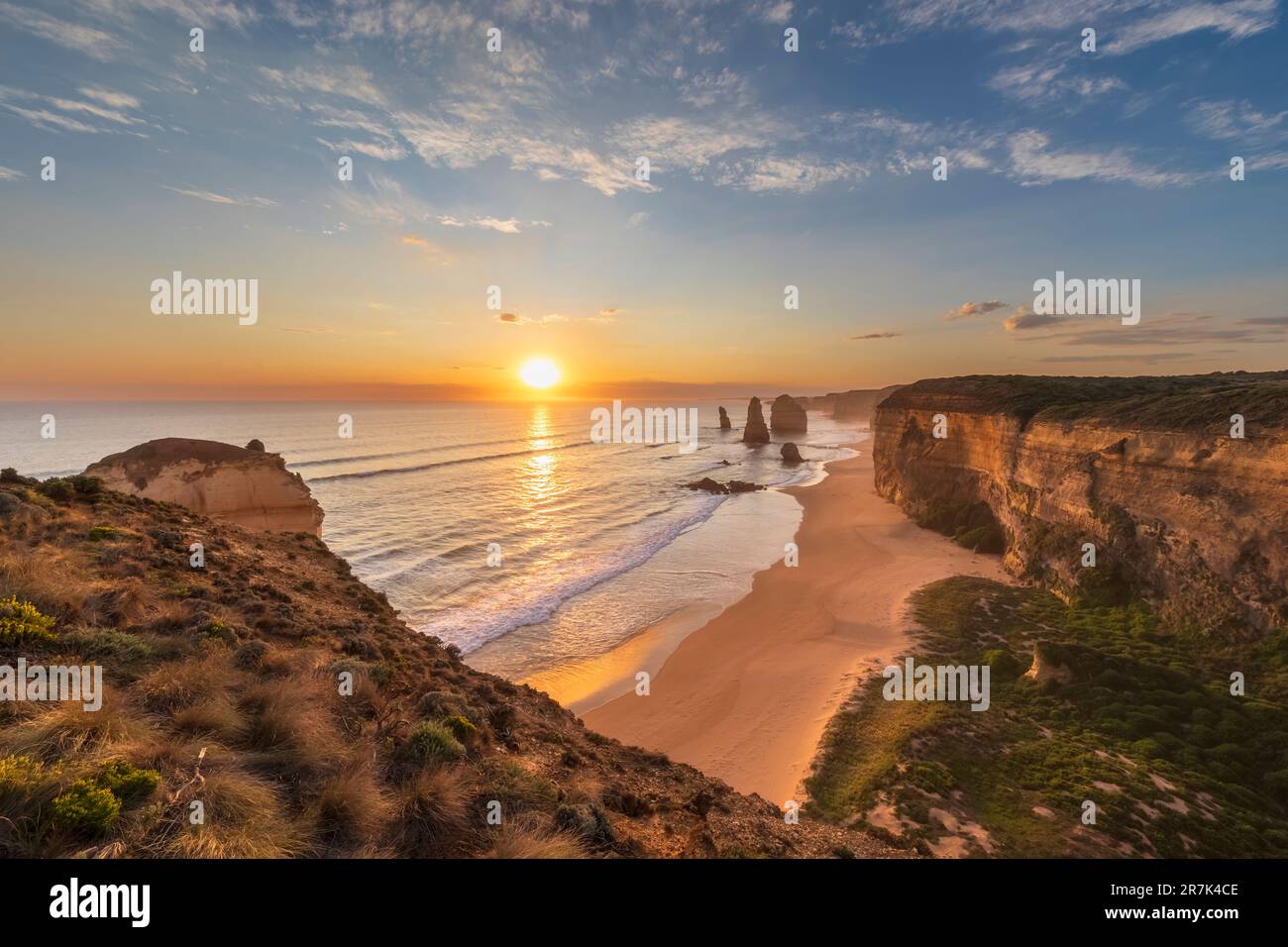 Australia, Victoria, Vista della spiaggia sabbiosa nel Parco Nazionale di Port Campbell al tramonto con dodici Apostoli sullo sfondo Foto Stock