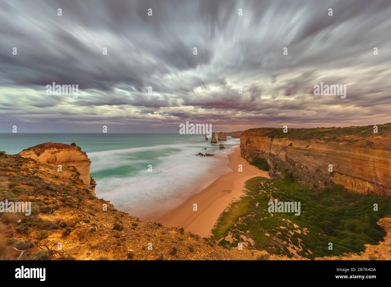 Australia, Victoria, lunga esposizione di spiaggia sabbiosa nel Parco Nazionale di Port Campbell all'alba nuvolosa Foto Stock