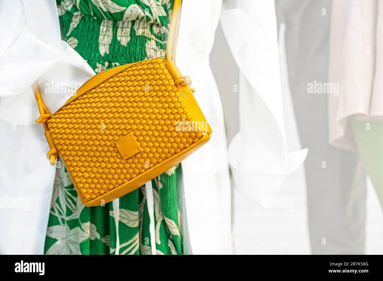 elegante borsa a pochette in tessuto giallo su un abito verde chintz. Moda tutti i giorni Foto Stock