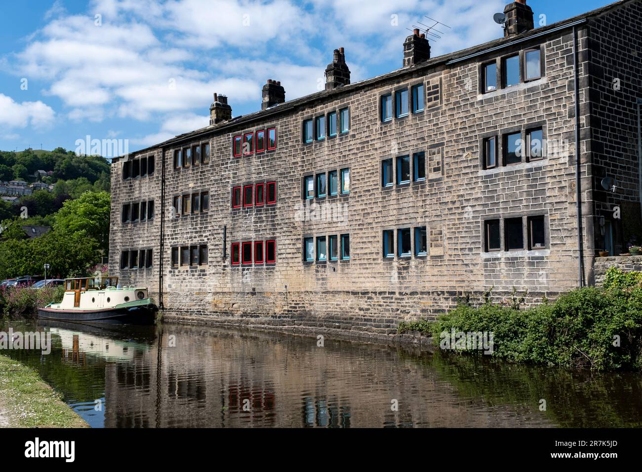 Scena di vecchi edifici di mulino industriale lungo il canale Rochdale il 7th giugno 2023 a Hebden Bridge, Regno Unito. Nei secoli 19th ° e 20th ° la città è stata conosciuta come Città stirapantaloni a causa della grande quantità di stoffa che è stato fabbricato presso i mulini. La posizione di Hebdens nella valle con i corsi d'acqua e i vicini mercati della lana lo hanno reso un luogo ideale per la produzione di tessuti. Hebden Bridge è una città commerciale situata nella Upper Calder Valley, nello Yorkshire occidentale. Durante gli anni '1970s e '1980s la città ha visto un afflusso di artisti, creativi e professionisti alternativi, nonché di attivisti verdi e del New Age. Più recentl Foto Stock