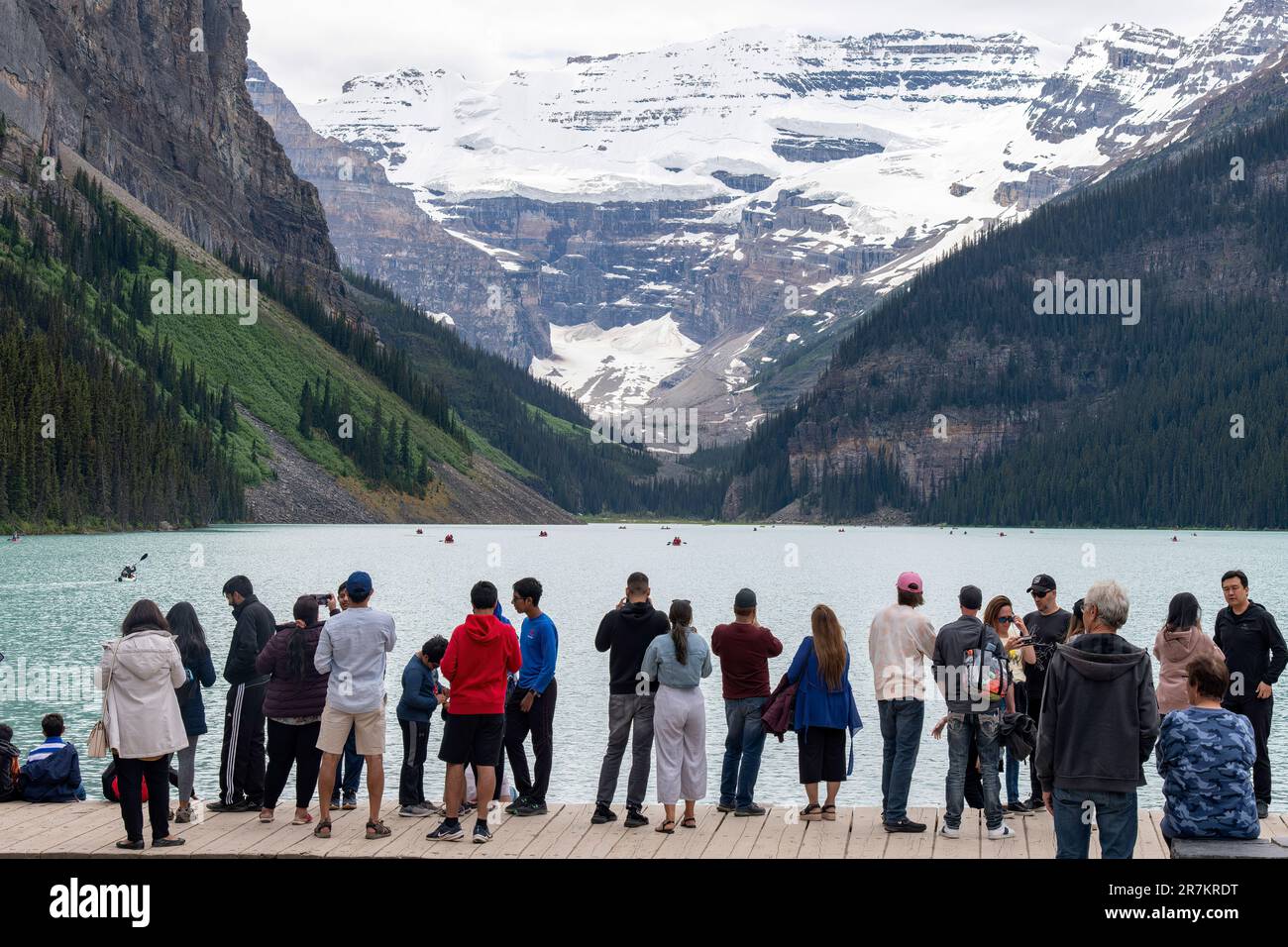 Lago Louise, AB, Canada-Agosto 2022; Visualizza molti turisti sul lungomare delle acque alimentate dal ghiacciaio del lago Louise con molte canoe sul lago contro la b Foto Stock