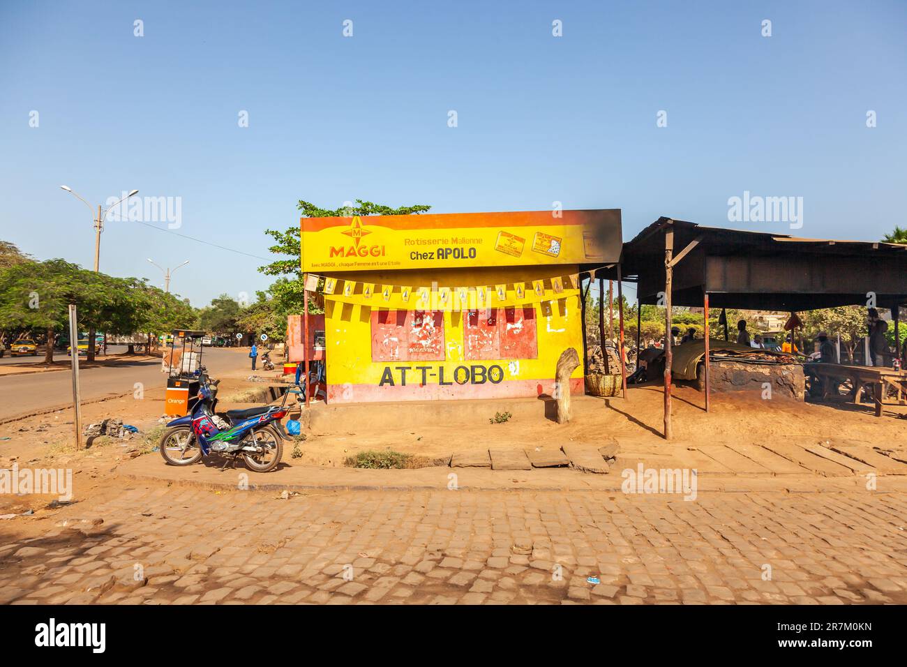 cabanon giallo e rosso sotto il segno di Apolo, un grill maliano. Bamako, Mali. Foto Stock