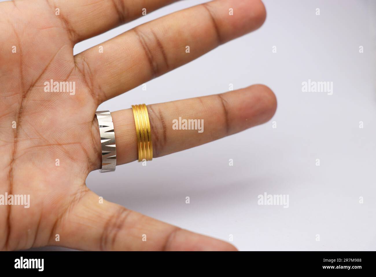 Un dito con un anello d'argento e un anello d'oro. in oro e argento Foto Stock