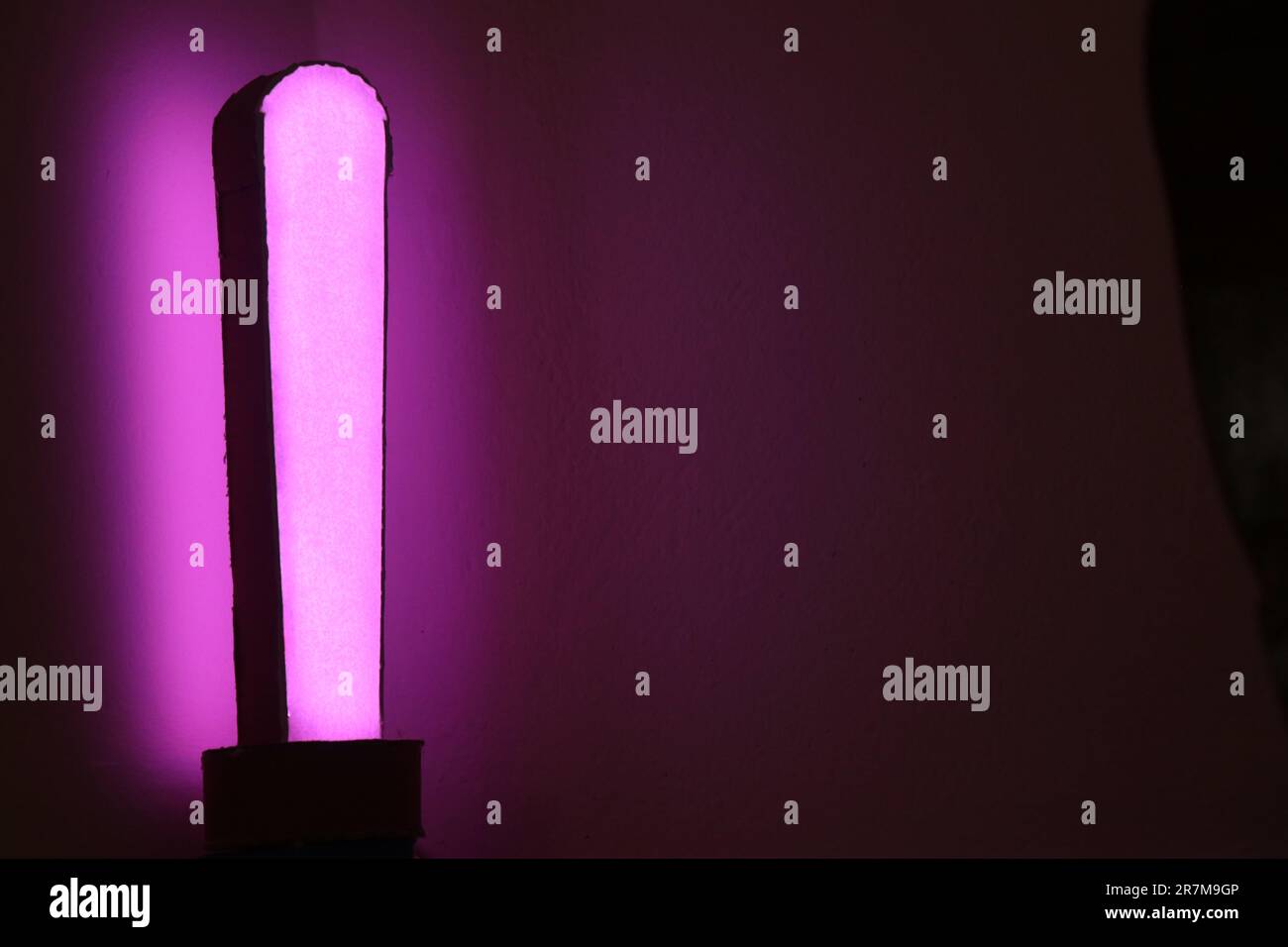 Moderna lampada da scrivania con luce viola. Lampada d'atmosfera con colori controllati da un telefono Foto Stock