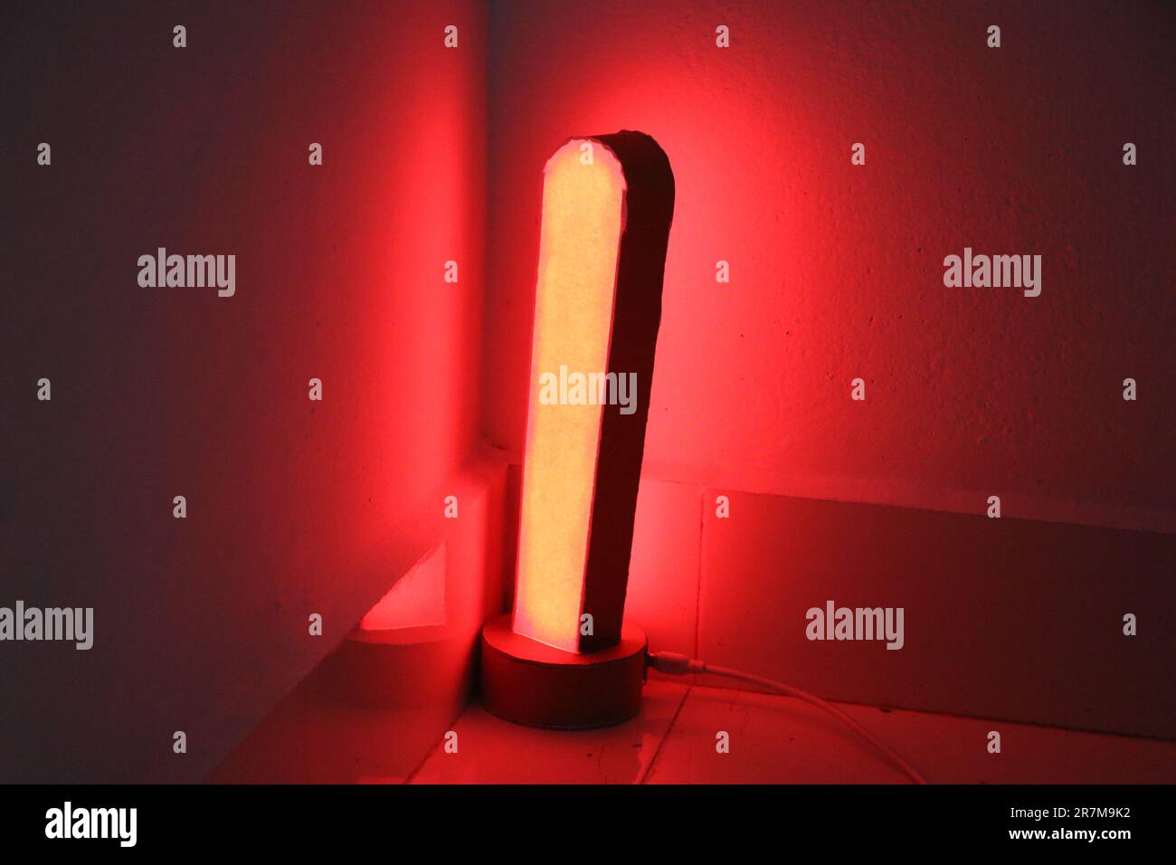 Luce d'atmosfera per l'arredamento della casa. Lampada intelligente realizzata a casa con emissione di colore rosso Foto Stock