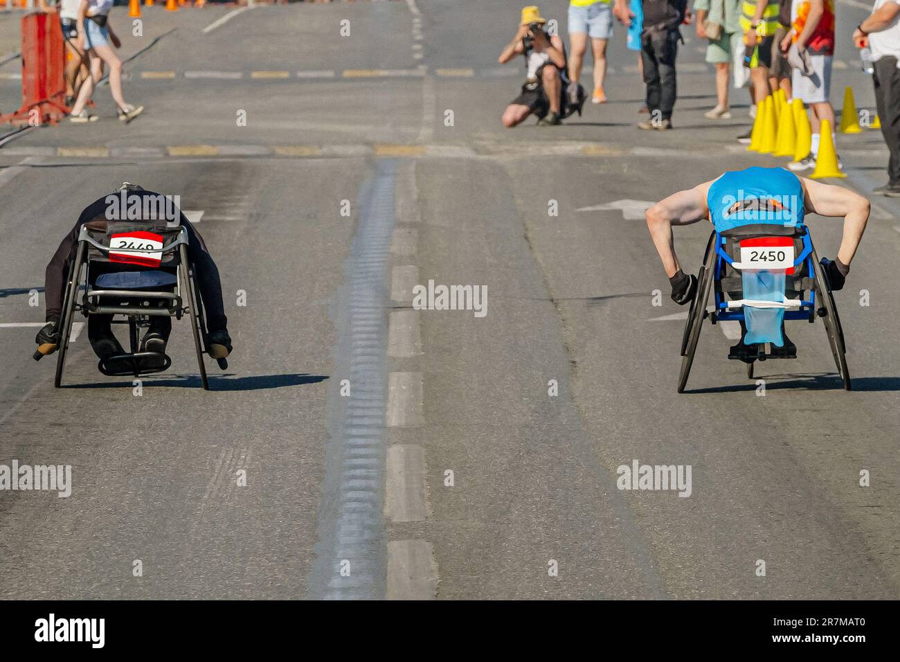 due gare su sedia a rotelle che vanno insieme alla gara di maratona, città estate atletica giochi sportivi Foto Stock