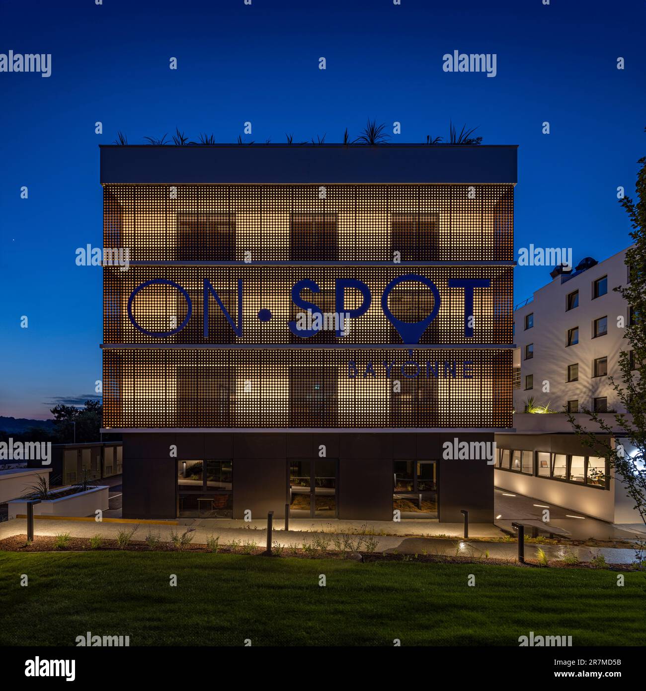 Vista notturna della costruzione Bayonne sul POSTO, edificio di uffici con servizi condivisi (spazi di coworking) nei Paesi Baschi (Bayonne, Francia). Foto Stock