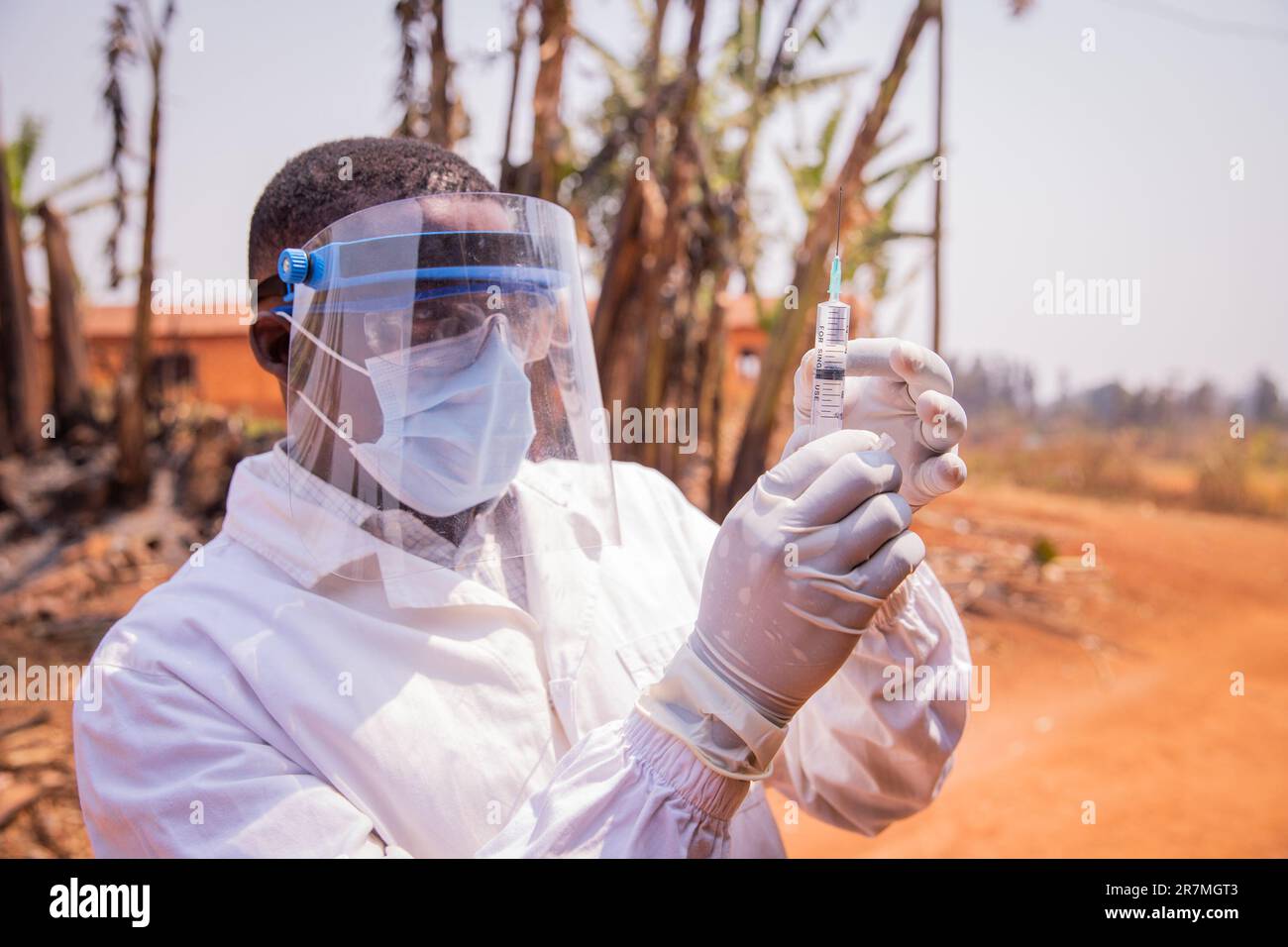 Un medico in Africa controlla la siringa del vaccino Foto Stock
