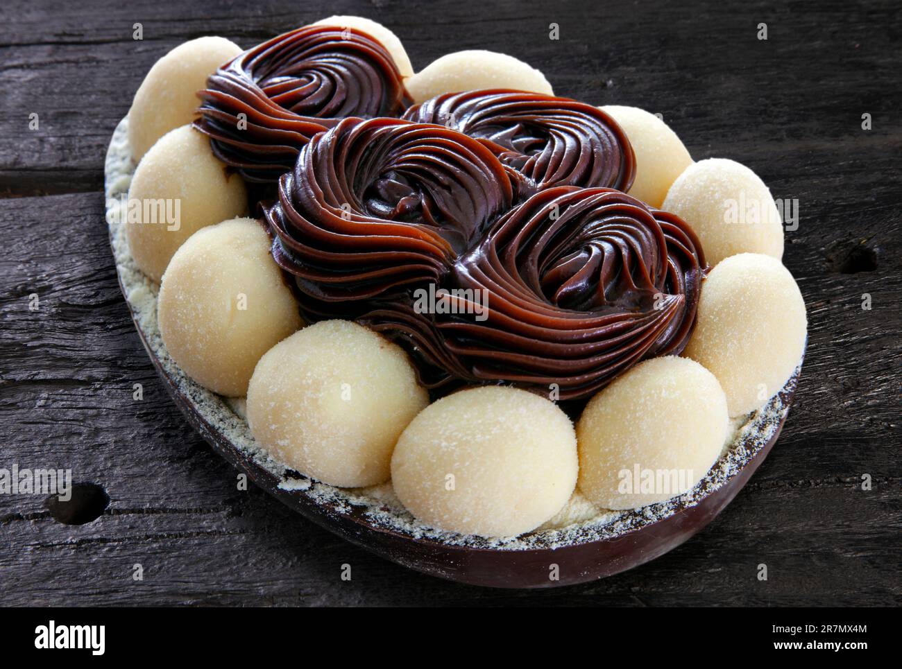 Uovo di pasqua brasiliano ripieno di cioccolato e crema, assaggiato con un cucchiaio. Tradizione pasquale in Brasile Foto Stock