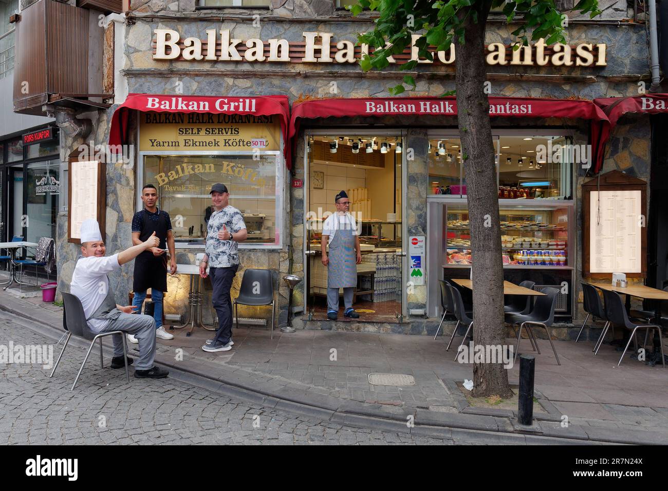 Il personale, incluso lo chef, dà il pollice fuori dal Balkan Grill Restaurant a Ortaköy, Istanbul, Turchia Foto Stock