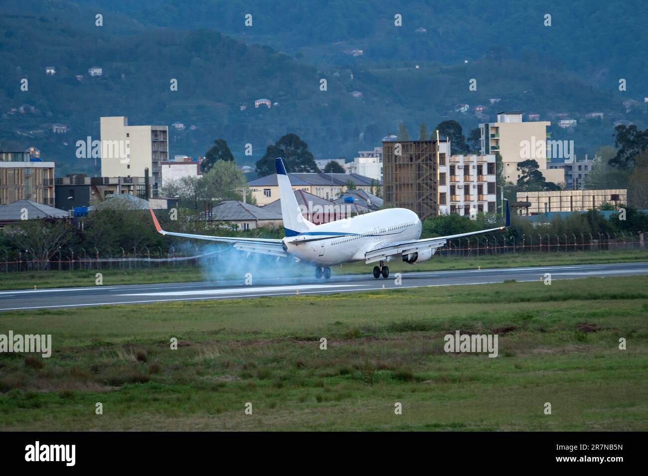 Aereo che atterra sulla pista all'aeroporto di Batumi in Georgia con fumo dal telaio Foto Stock