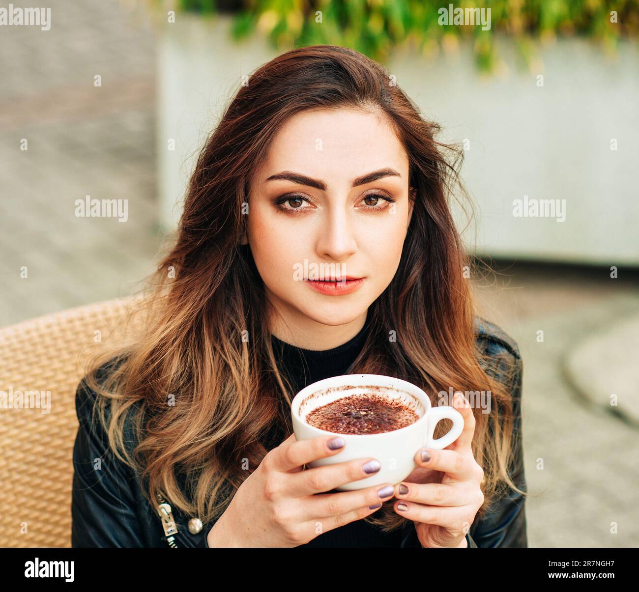 Bella giovane donna che beve caffè in terrazza Foto Stock