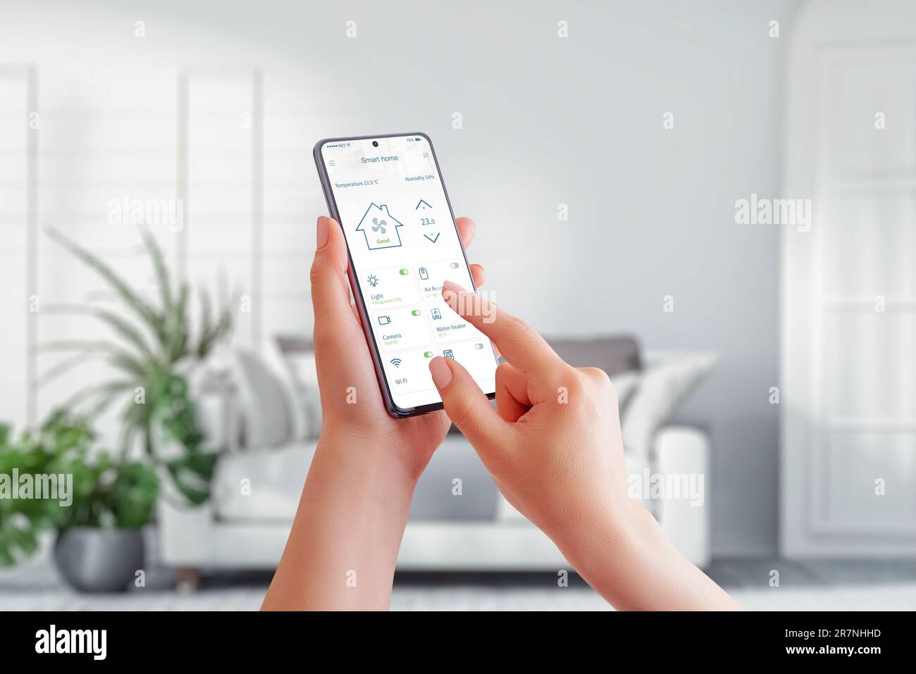 Gestione intelligente della casa con un telefono cellulare in mano a una donna, connessione perfetta a un'app per la casa intelligente e comfort di un elegante li Foto Stock