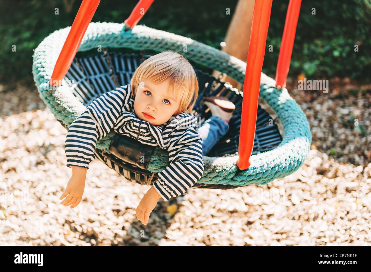 Bambina che si diverte nel parco, bambino di 2-3 anni che gioca nella grande altalena, parco giochi, attività per bambini Foto Stock