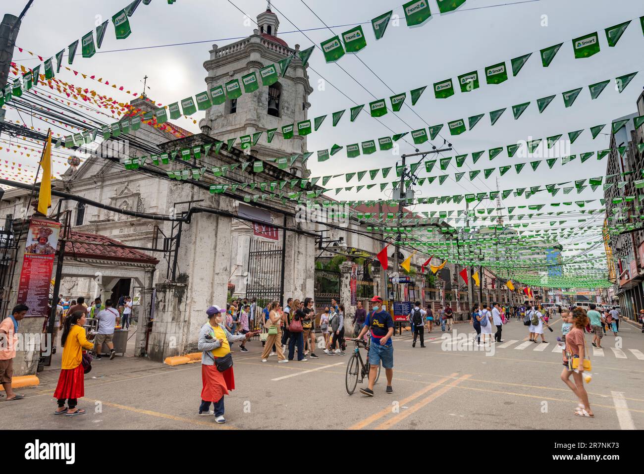 Città di Cebu, Cebu, Filippine-Gennaio 17 2023: Le persone filippine si mescolano nelle strade che corrono accanto alle porte della famosa e più antica Chiesa di Cebu, AS Foto Stock