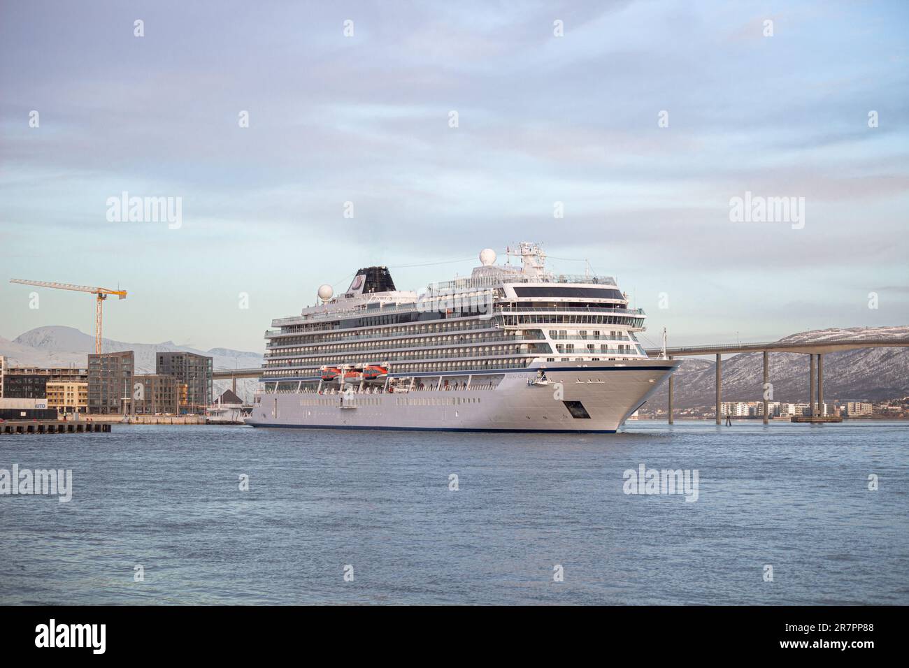 Una maestosa nave da crociera vichinga Venere ormeggiata nel porto di Tromso, contro le montagne innevate Foto Stock