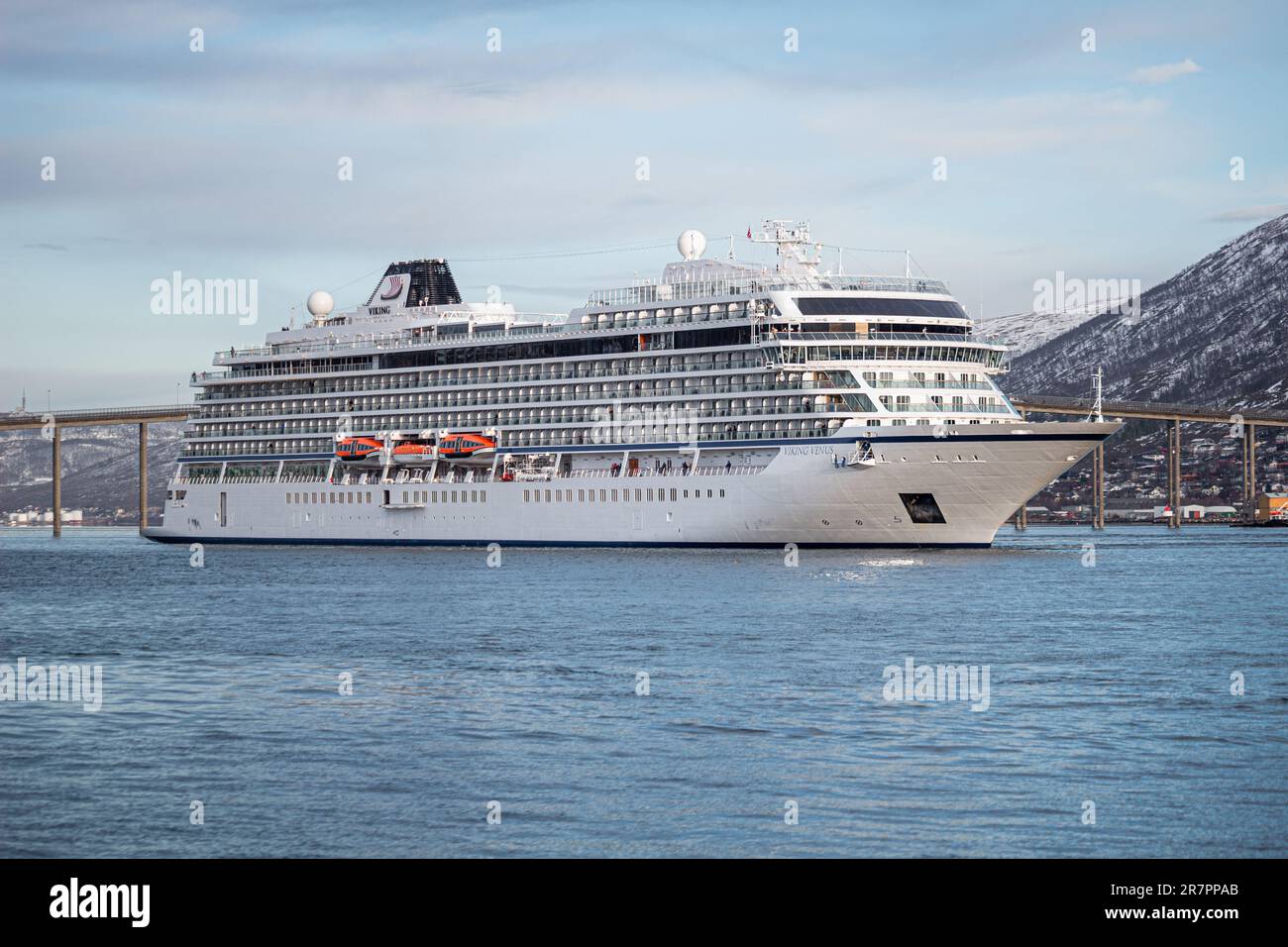 Una maestosa nave da crociera vichinga Venere ormeggiata nel porto di Tromso, contro le montagne innevate Foto Stock