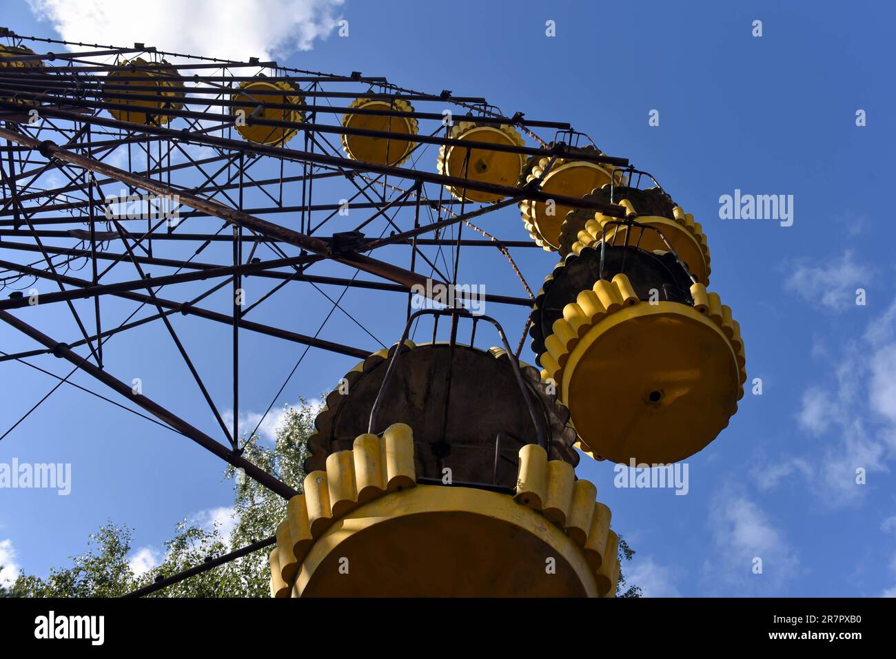 Una ruota panoramica gialla nella città abbandonata di Pripyat sullo sfondo del cielo blu Foto Stock