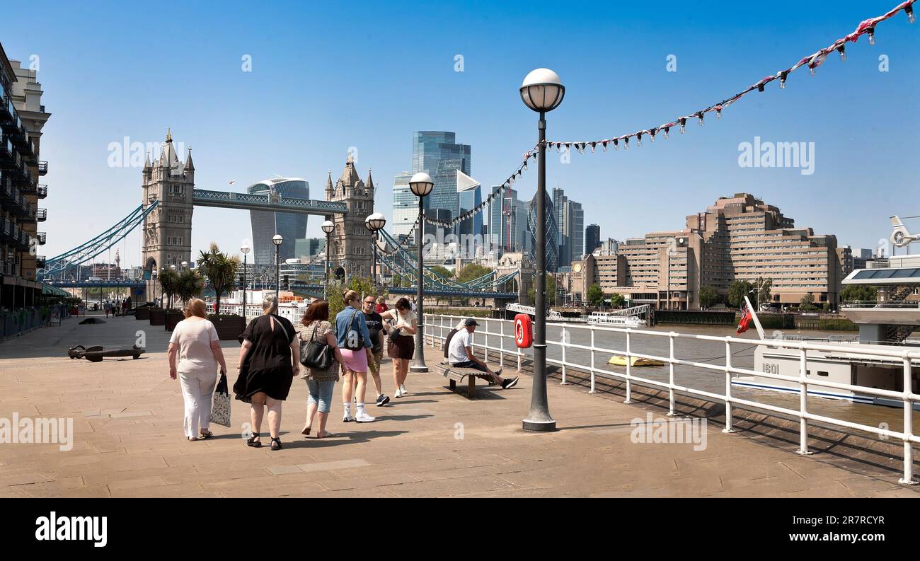 Tourista godendo di una passeggiata estiva lungo la London South Bank, ad est del Tower Bridge Foto Stock