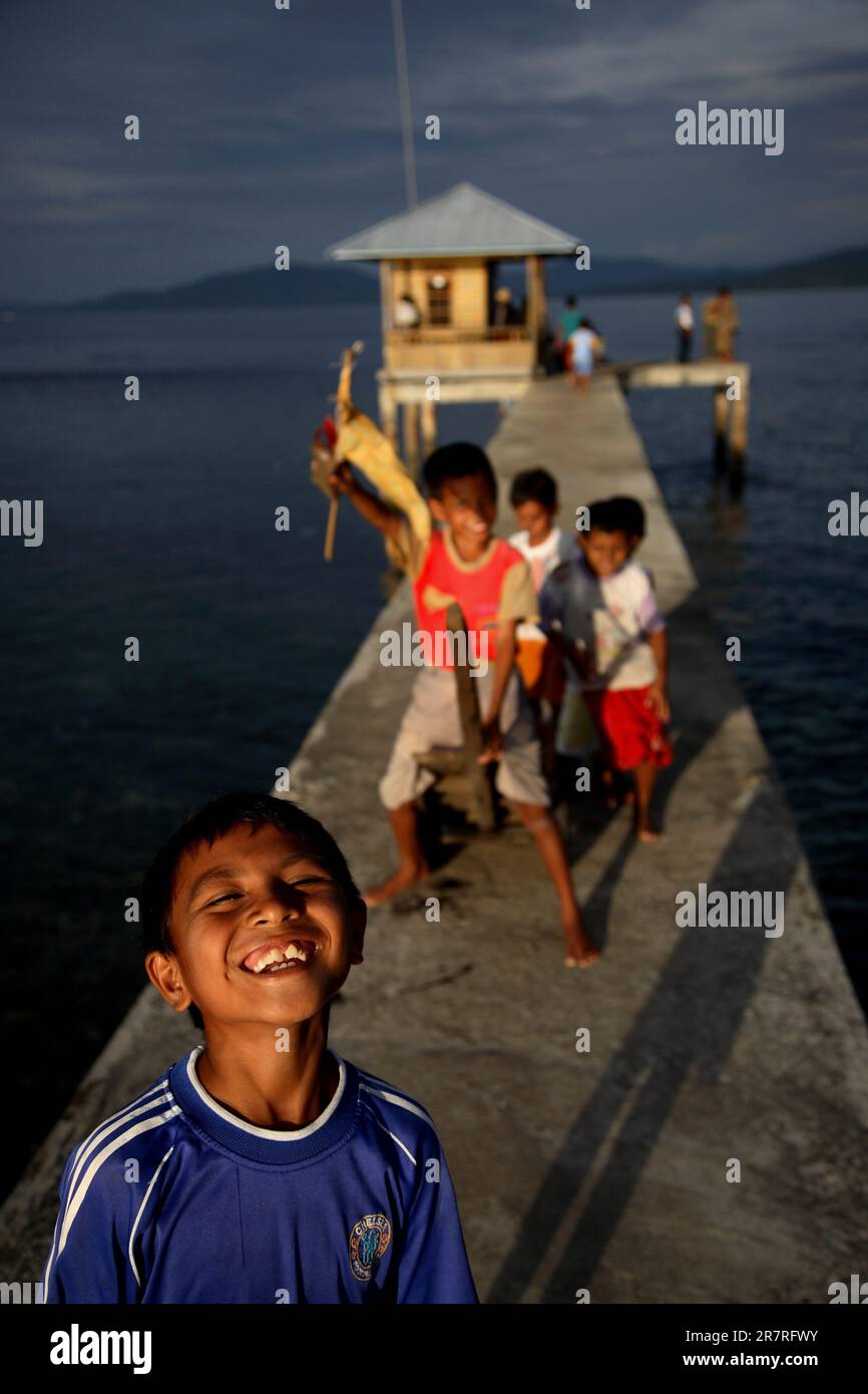 Bambini che giocano in un molo. Bunaken, Sulawesi settentrionale, Indonesia. Foto Stock