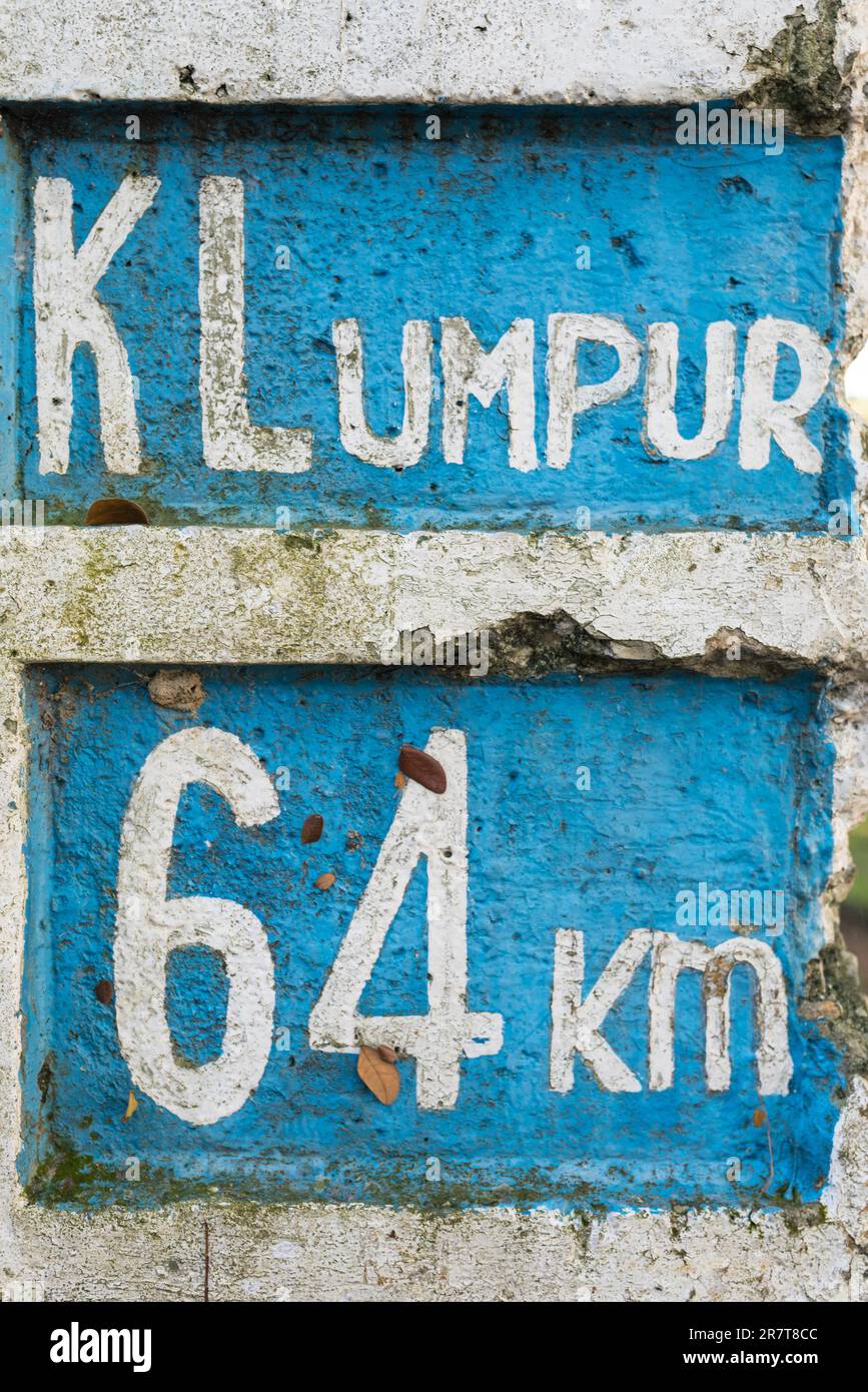 Vecchia pietra miliare con chilometri di distanza dalle città in Malesia in un parco pubblico di Kuala Lumpur, la capitale della Malesia Foto Stock