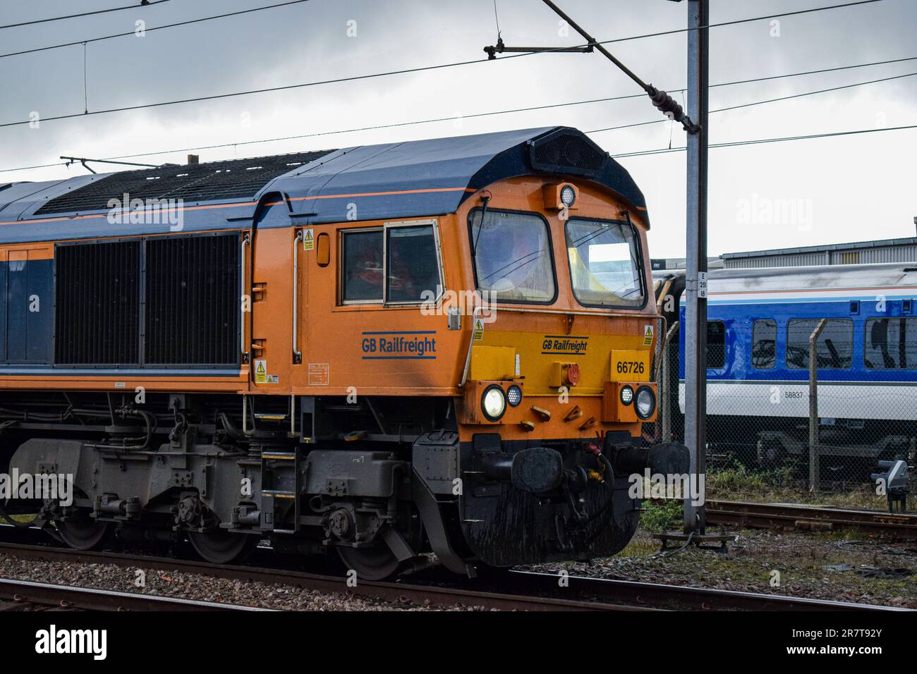 Una GBRf Class 66 si trova a Doncaster, in attesa del segnale verde per continuare. Una DMU Chiltern memorizzata si trova sullo sfondo. Foto Stock