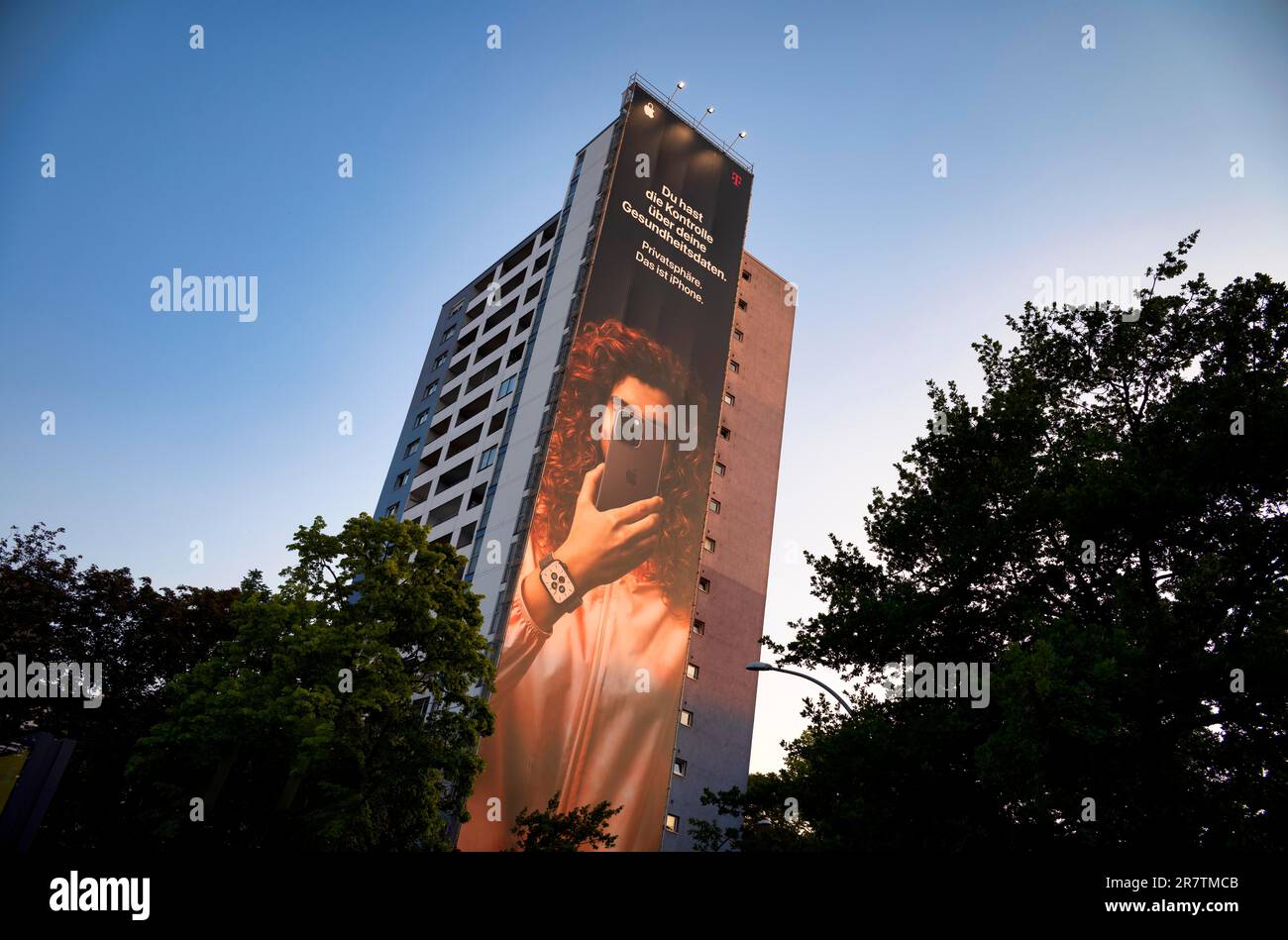 Grande poster pubblicitario, banner, poster di Apple iPhone e Telekom come pubblicità congiunta sulla facciata esterna di un alto edificio in Foto Stock