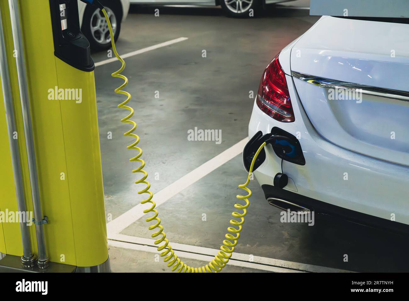 Le auto elettriche vengono addebitate dalla stazione di ricarica nel parcheggio interno del centro commerciale. Foto Stock