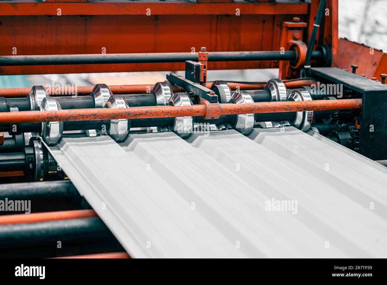 Linea di produzione di macchine per la formatura di lamiere grecate nella fabbrica di pannelli metallici. Foto Stock