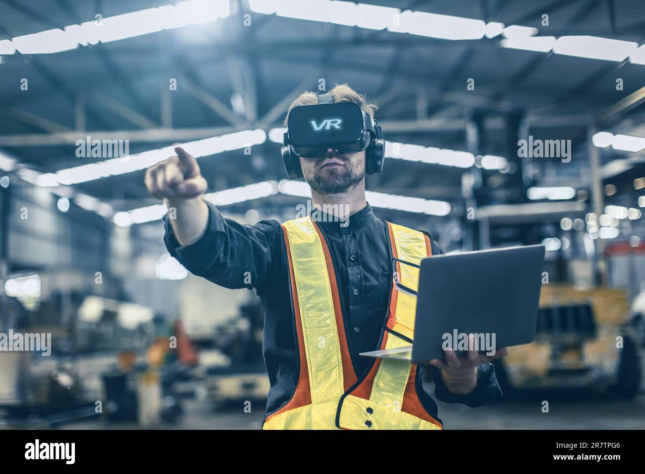 Ingegnere maschio utilizzando la tecnologia di realtà virtuale in realtà virtuale nella moderna fabbrica di warehouse di nuova progettazione innovativa Foto Stock