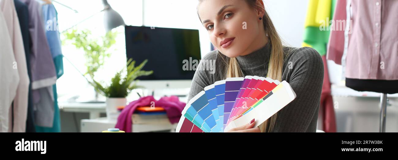 Donna stilista seamstress lavorare in studio tenendo tavolozza di colori. Selezione e scelta della soluzione colore nella collezione di abbigliamento Concept Foto Stock