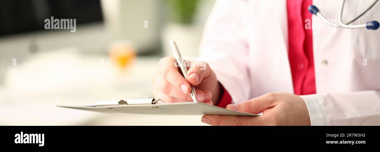 Donna medico di medicina con penna d'argento scrive su un closeup appunti. Calcolo medico e statistica e concetto di assicurazione Foto Stock