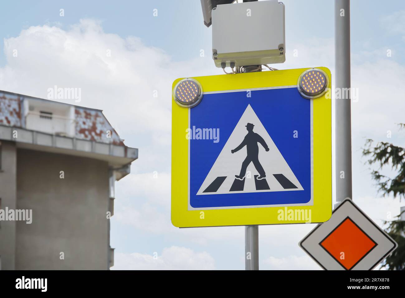 Segnaletica stradale Pedestrian Crossing e strada principale contro il cielo all'aperto Foto Stock