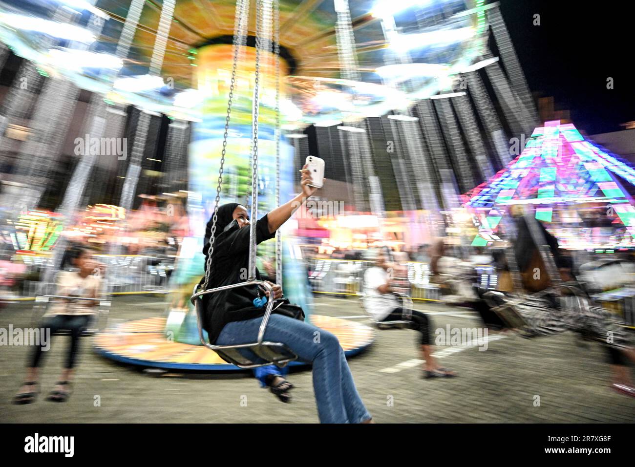 Tangerang, Indonesia. 17th giugno, 2023. Una donna prende selfie mentre cavalca una giostra in un centro commerciale, a Tangerang, provincia di Banten, Indonesia, il 17 giugno, 2023. Credit: Agung Kuncahya B./Xinhua/Alamy Live News Foto Stock