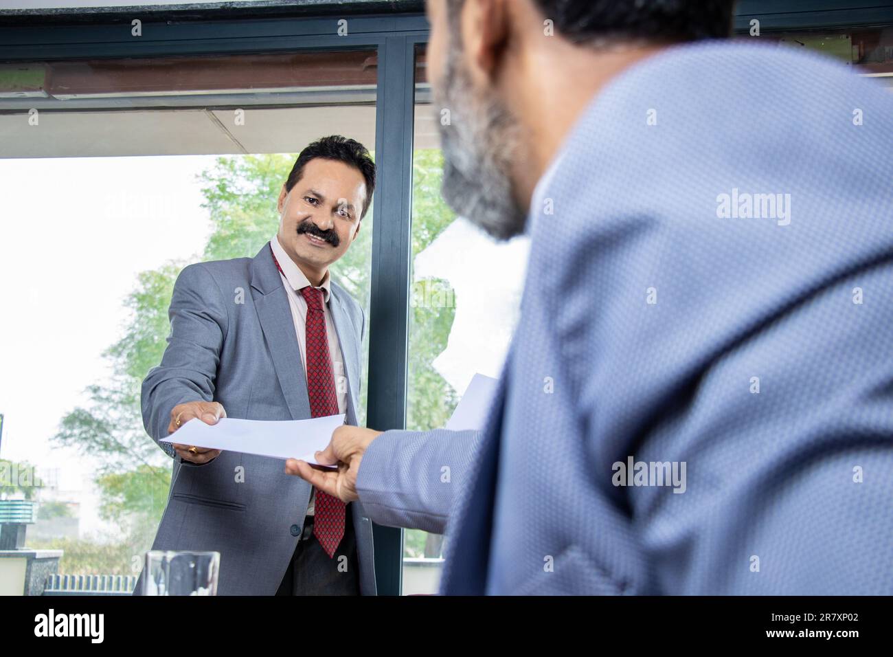 Uomo d'affari indiano dare rapporto carta a collega, Finanza e performance statistiche di business. Intervista di lavoro, uomo dare curriculum, Manager riceve appli Foto Stock