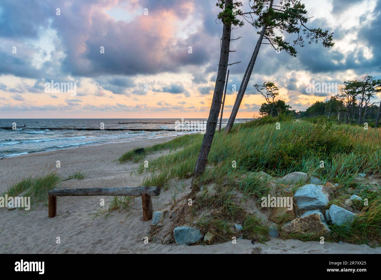 Ingresso alla spiaggia del Mar Baltico all'alba. Bel cielo drammatico. Balaustra in legno in primo piano. Mar Baltico, Polonia Foto Stock
