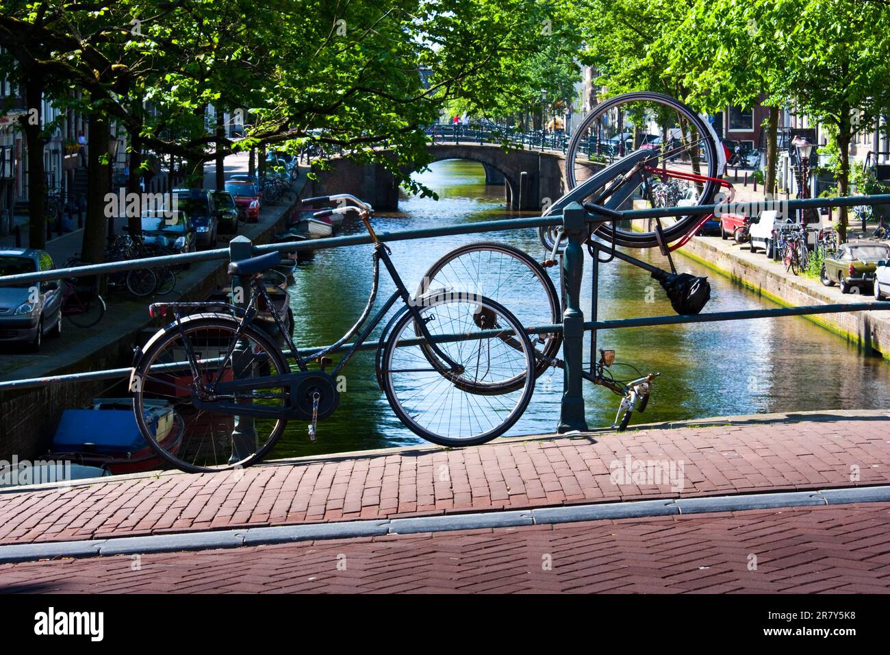 Parcheggio per biciclette tipico ad Amsterdam, di fronte ad un canale tipico Foto Stock