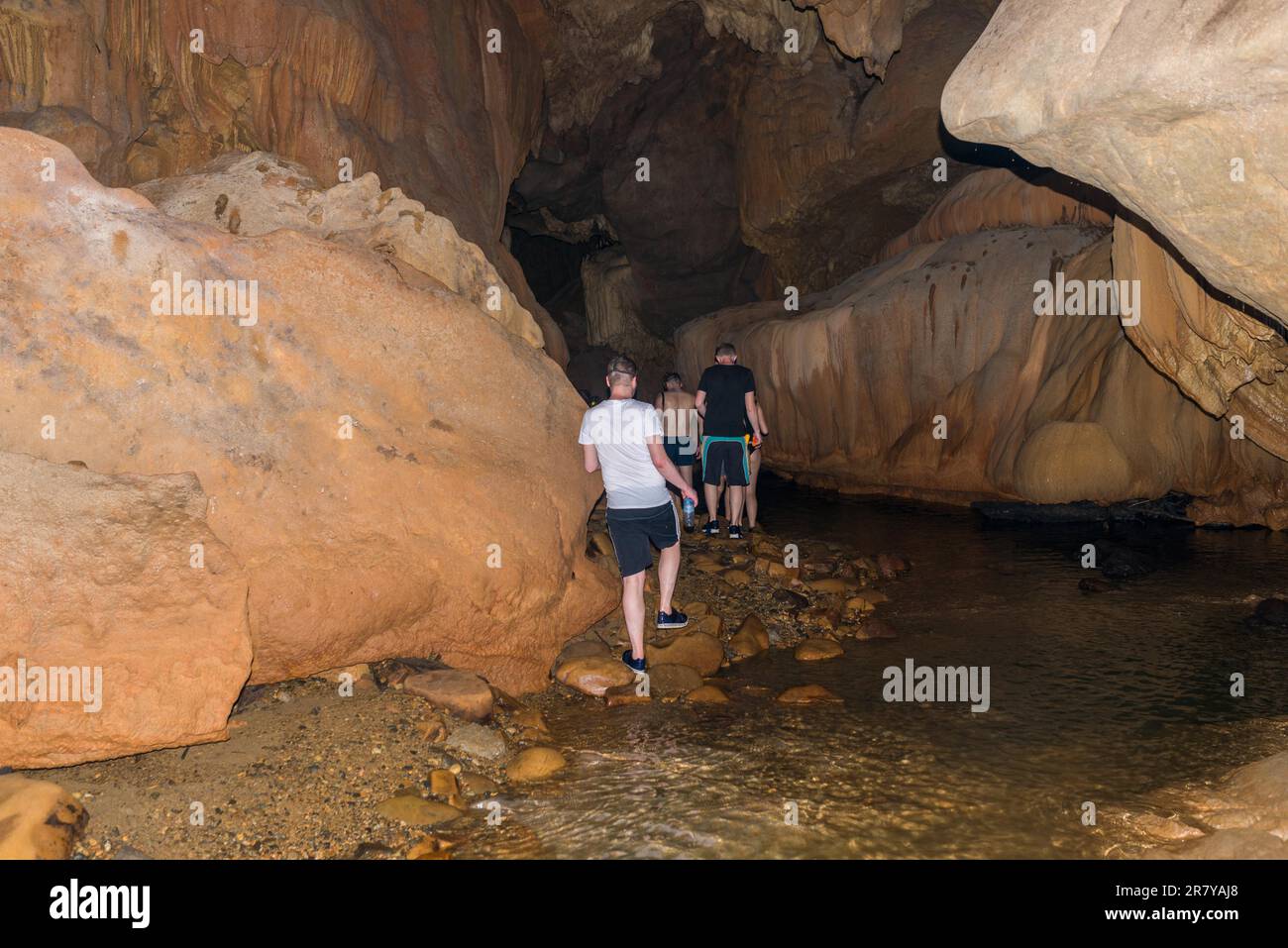 I turisti con guida fanno speleologia e hanno avventura nella grotta Nam Talu nel parco nazionale Khao Sok in Thailandia Foto Stock