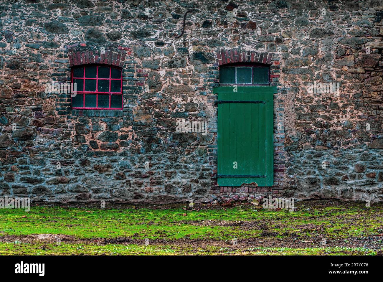 Facciata della fattoria con finestra rossa e porta verde Foto Stock