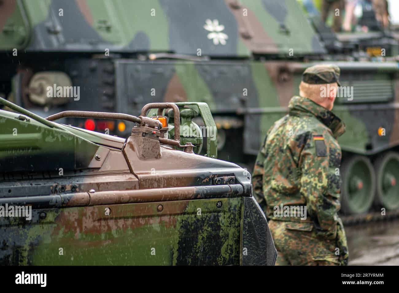 Soldato tedesco che cammina vicino ai carri armati armati in movimento obice semovente Panzerhaubitze 2000 o PzH 2000, esercito tedesco Foto Stock